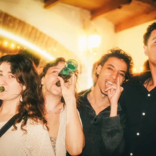 Four people drinking beer and smiling for a photo.