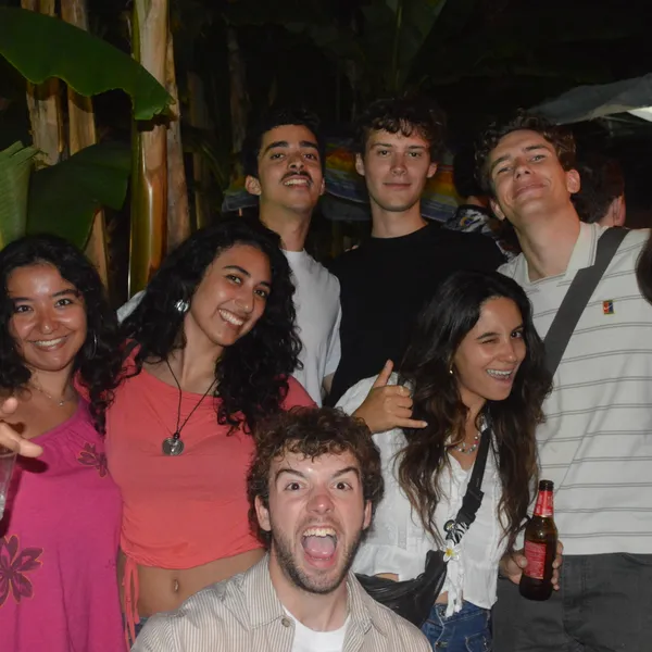 A group of people smiling and posing for a photo together at night.