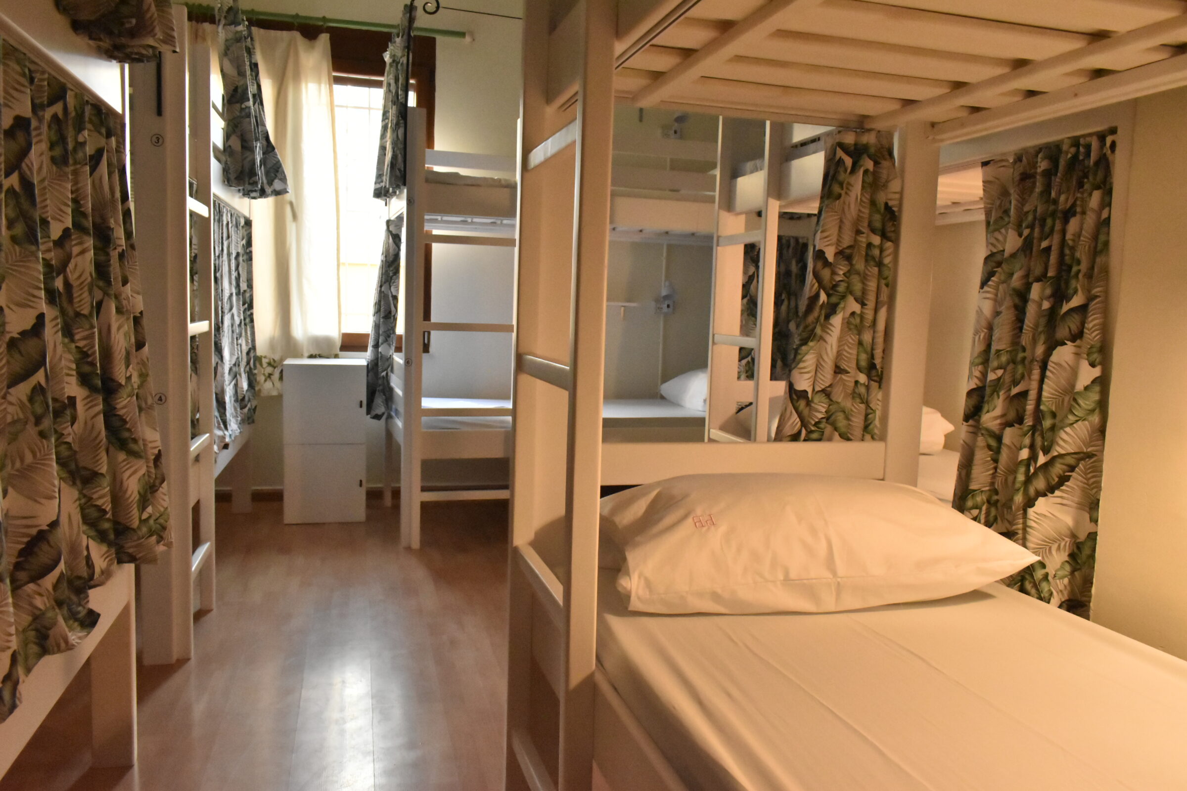 Shared dorm room with bunk beds and privacy curtains